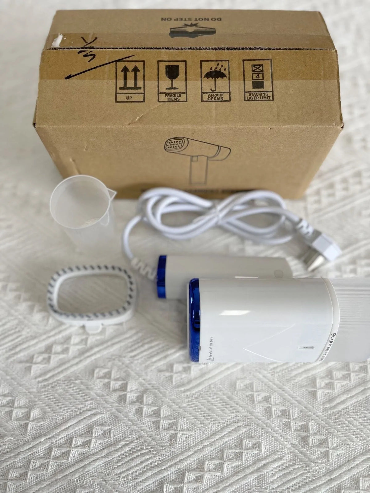 Portable handheld garment steamer in white foldable design with non-stick liner and UK plug