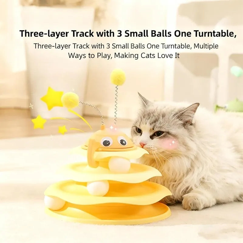 Cat toy tower with rotating bee toy and three-layer trackball in green plastic, placed on a wooden floor