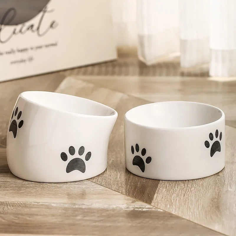 Ceramic cat bowl with cat paw design in black, showing oblique mouth style.