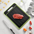 Grey square aluminium cutting board with defrosting side, grinder teeth, and integrated knife sharpener.