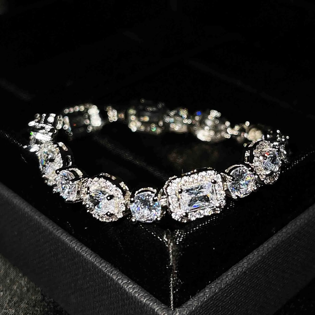 Close-up of a women's geometric silver bracelet with inlaid zircon stones on a wrist, showing adjustable chain.