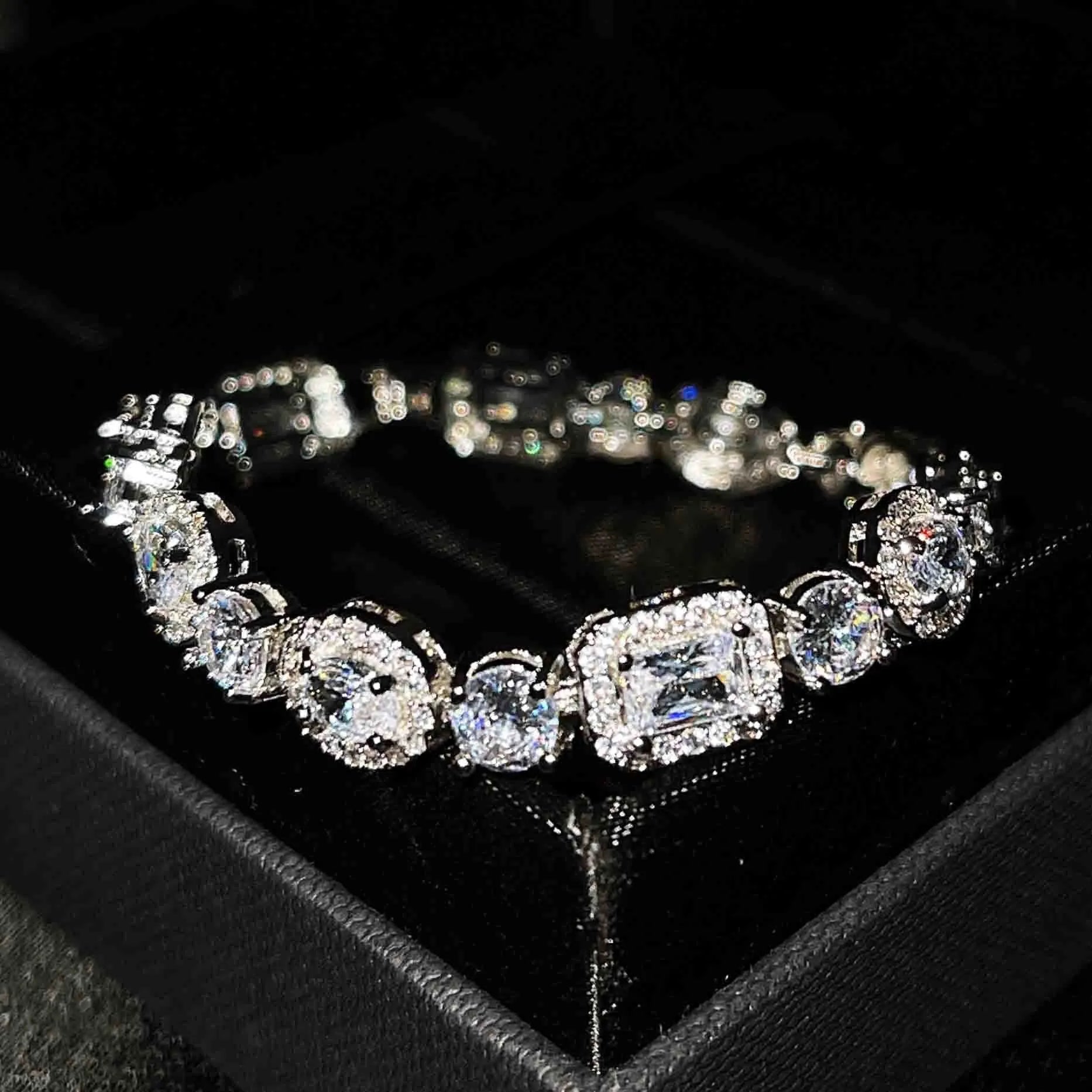 Close-up of a women's geometric silver bracelet with inlaid zircon stones on a wrist, showing adjustable chain.