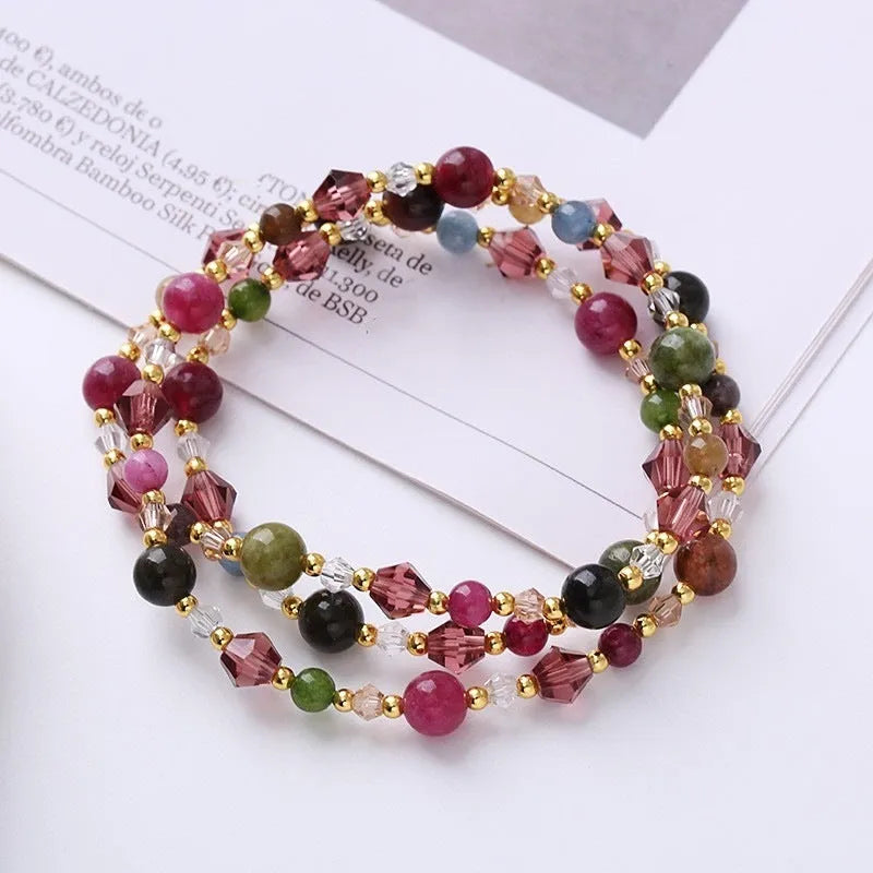 Women's three-ring crystal bracelet with tourmaline, strawberry quartz, and amethyst stones on adjustable rope