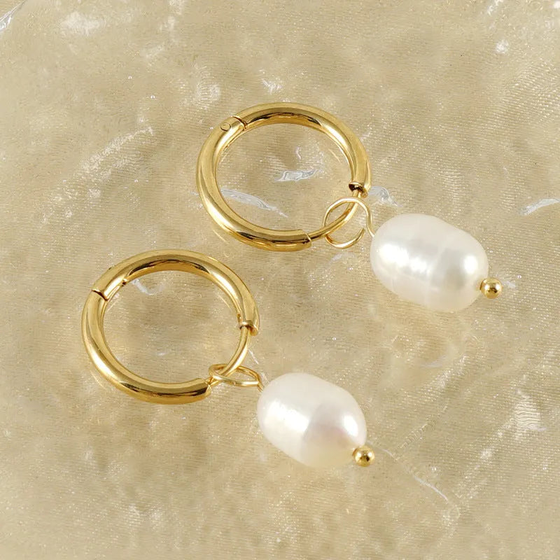 A pair of gold geometric-shaped stainless steel earrings featuring a central pearl and titanium steel posts.