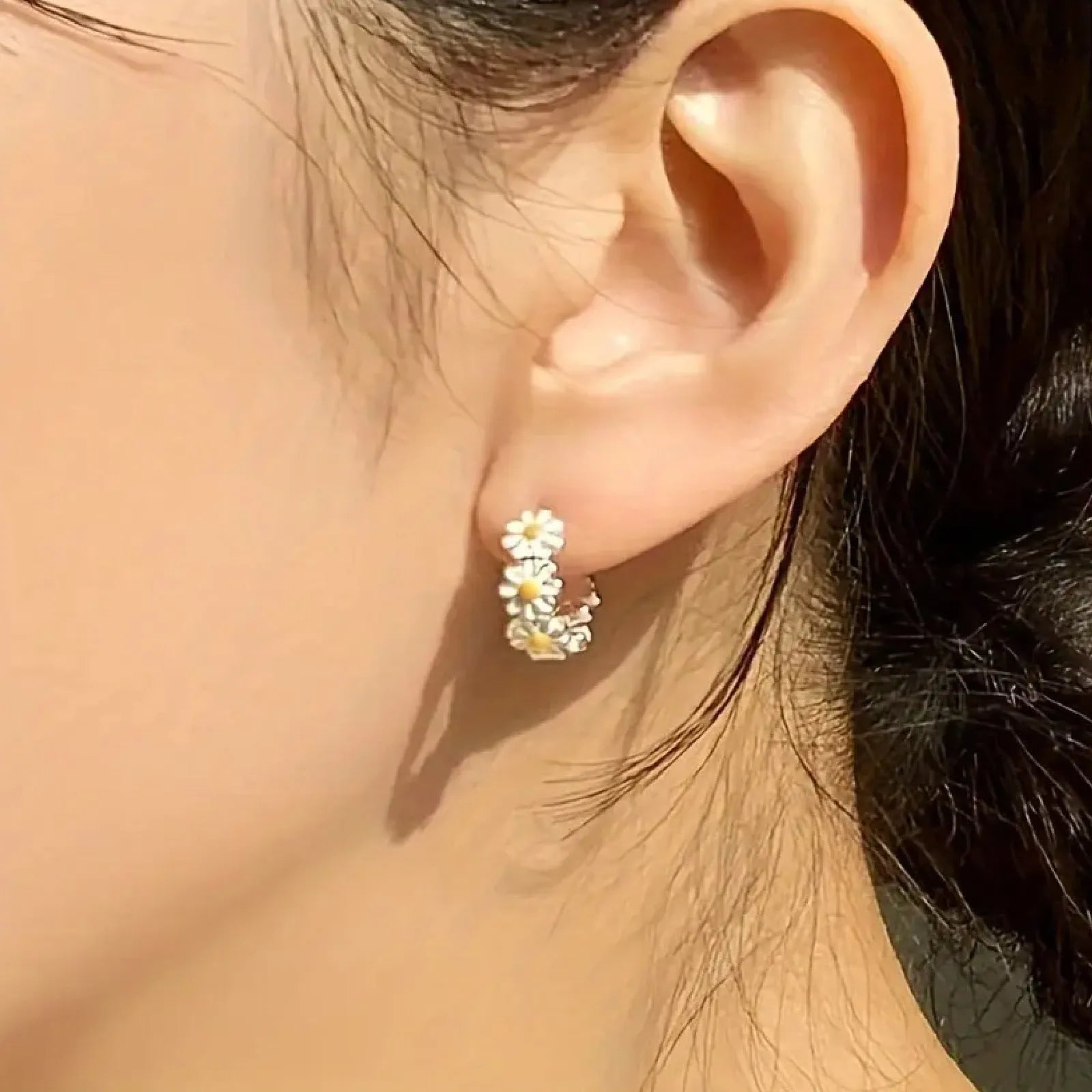 White electroplated copper daisy flower earrings with platinum gem inlay on white background