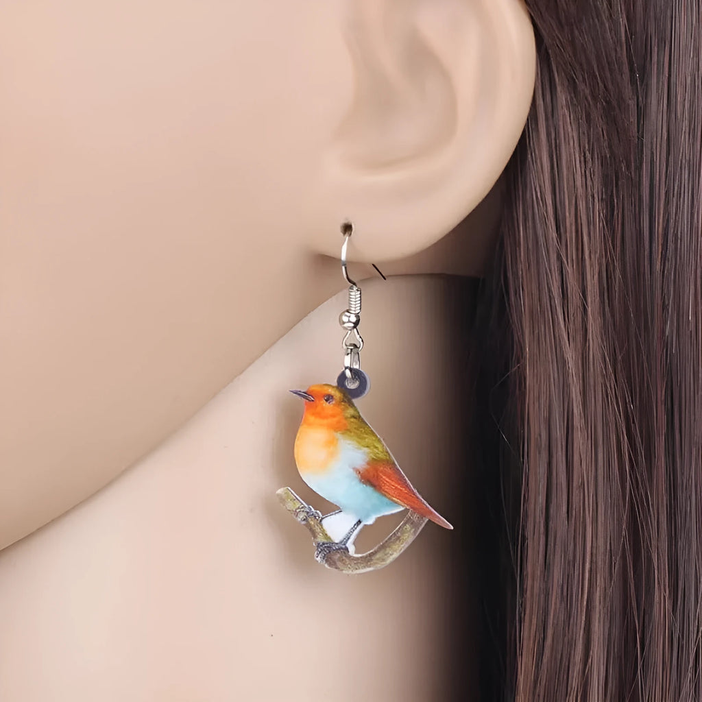 Blue Titmouse bird pendant acrylic earrings with silver snake chain detail on a white background.