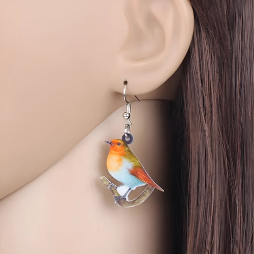 Blue Titmouse bird pendant acrylic earrings with silver snake chain detail on a white background.
