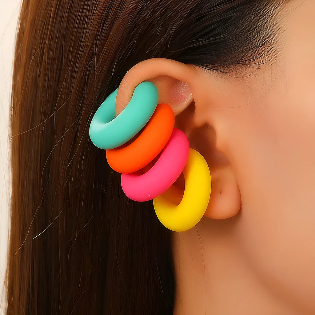 Close-up of matte finish, coarse round C-shaped clip-on earrings for women in a candy colour.