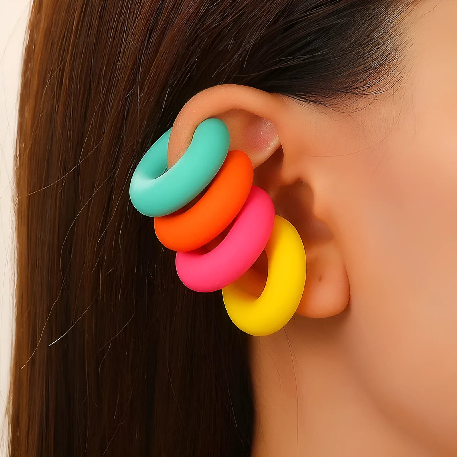 Close-up of matte finish, coarse round C-shaped clip-on earrings for women in a candy colour.