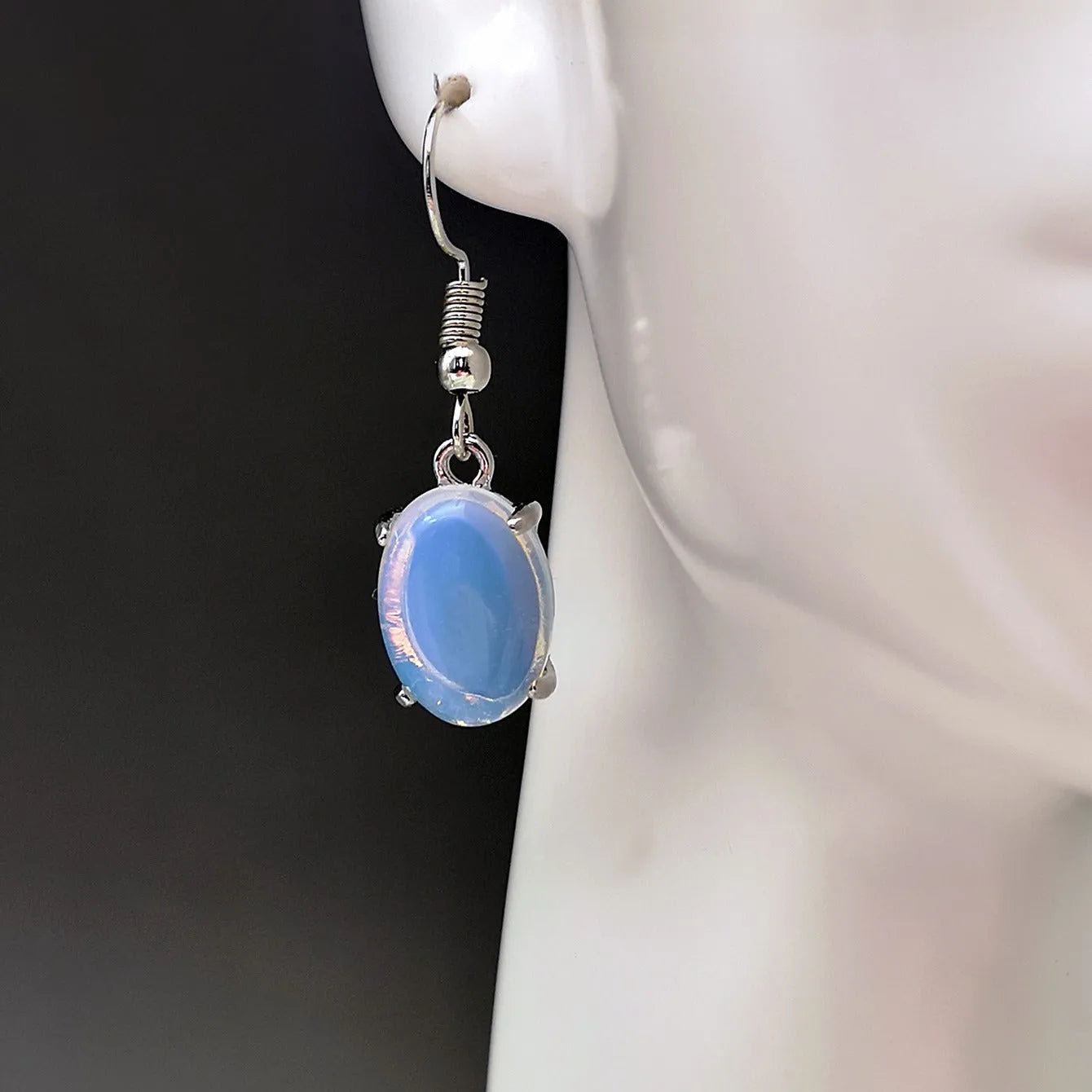 A pair of retro drop-shaped alloy earrings with electroplated moonstone opal colour and ellipse design elements.