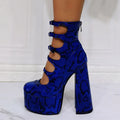 Women's black patent leather platform high heels with a thick heel and serpentine belt buckle.