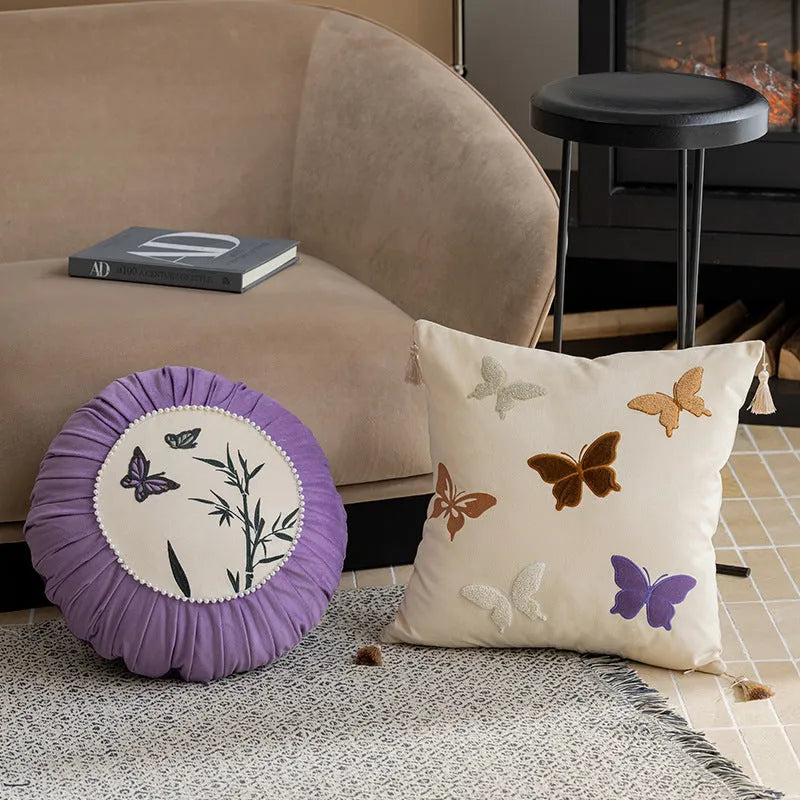 Square decorative cushion with Chinese-style butterfly embroidery in beige, black, and purple colours.