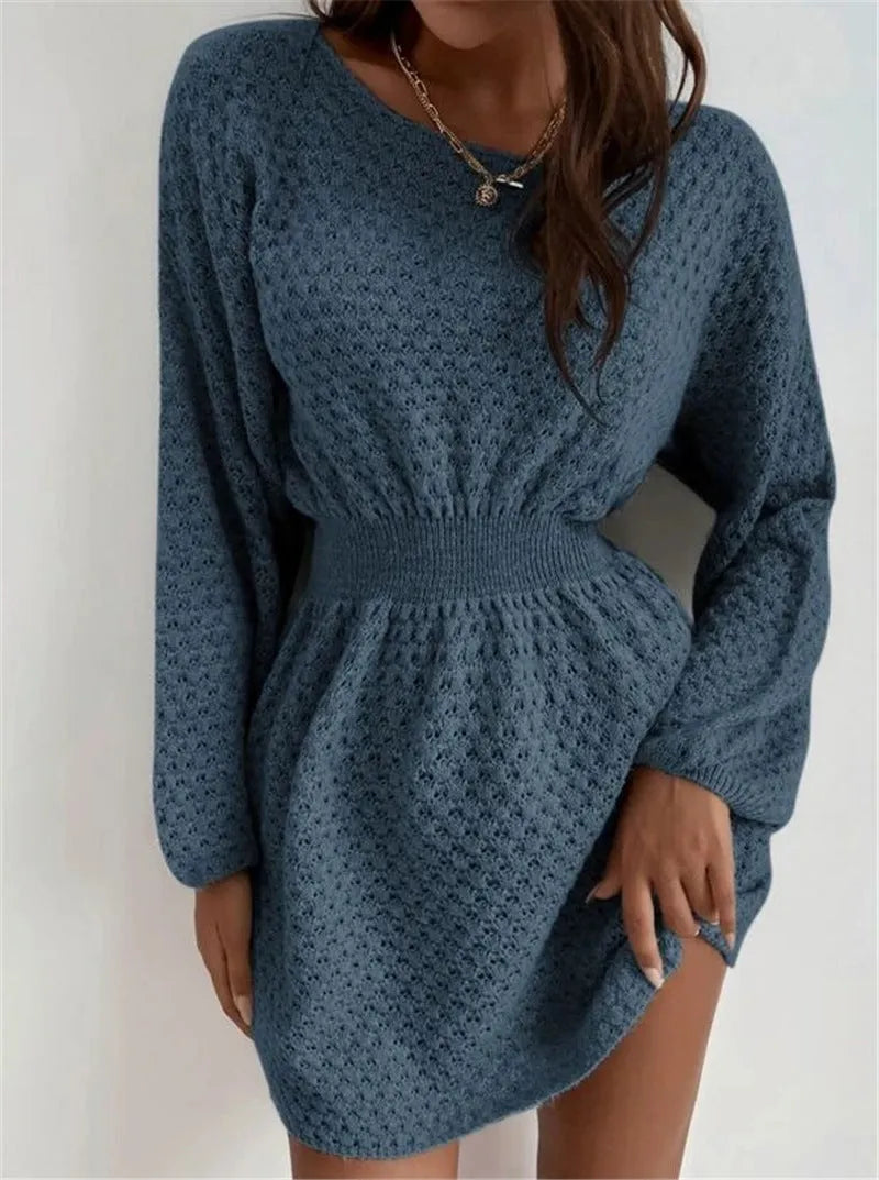 Blue knitted dress with fitted waist, round neck, long sleeves, and white crocheted flower details.