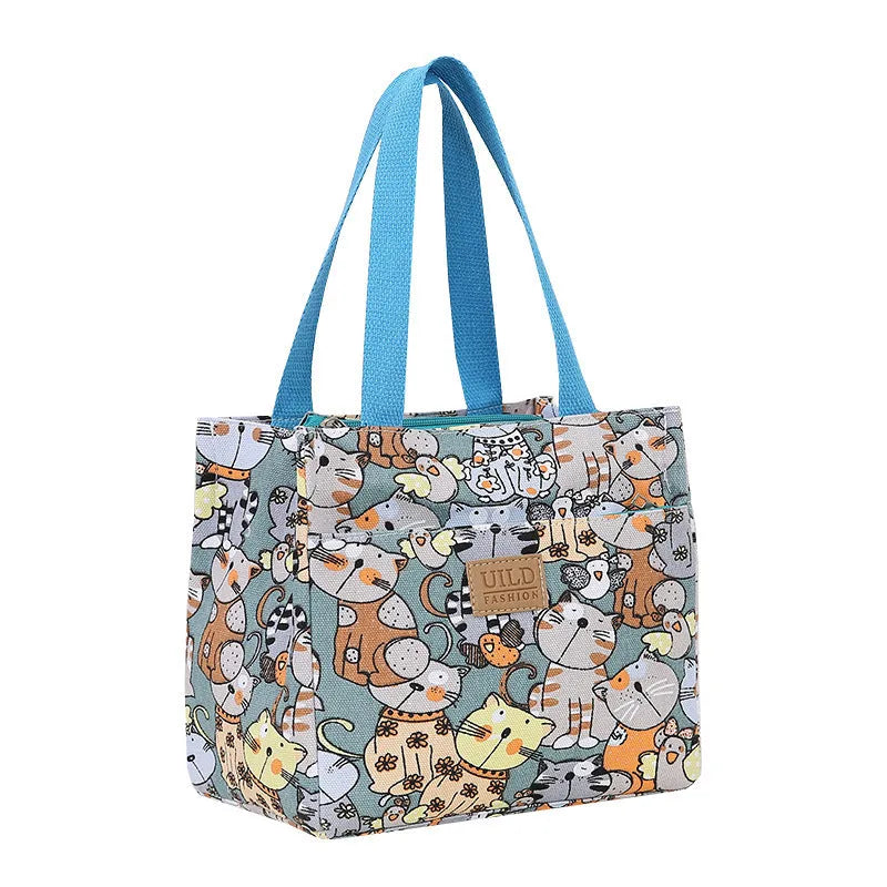 Women's printed canvas tote bag with aluminium handles in a floral or cat design.
