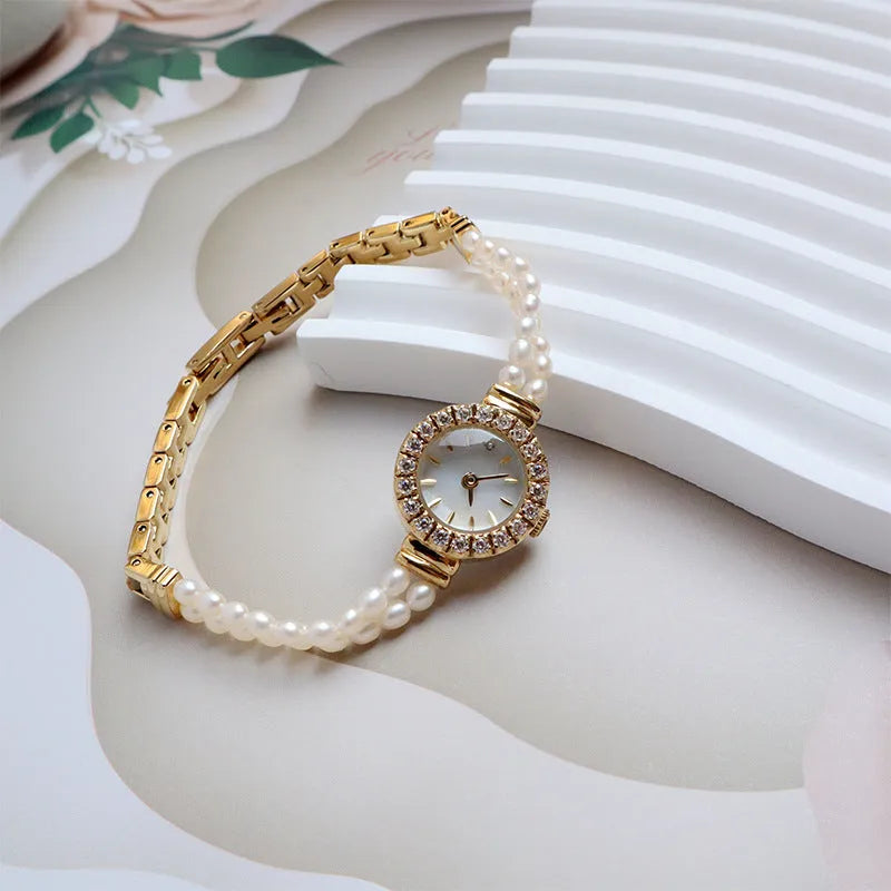 Light gold women's bracelet watch with freshwater pearls and a round 18mm dial.