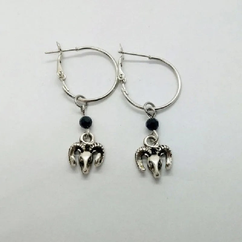 A pair of silver-coloured round ring earrings featuring a detailed Tibetan antelope design.