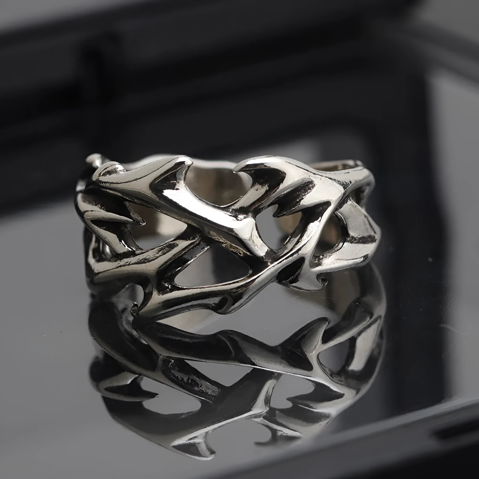 Copper men's ring with thorn and flower design on a geometric band, showing adjustable opening.