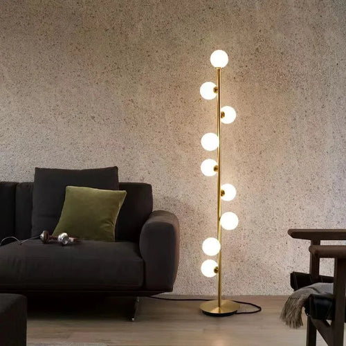 A tall, minimalist Nordic-style floor lamp with a wrought iron frame, glass details, and a circular marble base.