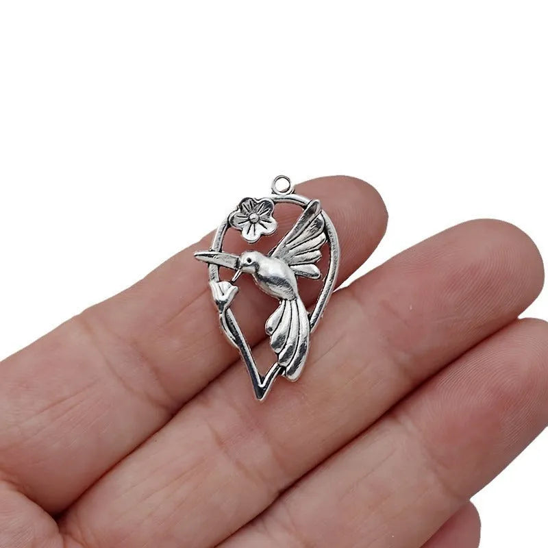 Close-up of a silver-toned magpie-shaped alloy pendant for DIY jewellery making, showing detailed feathers.
