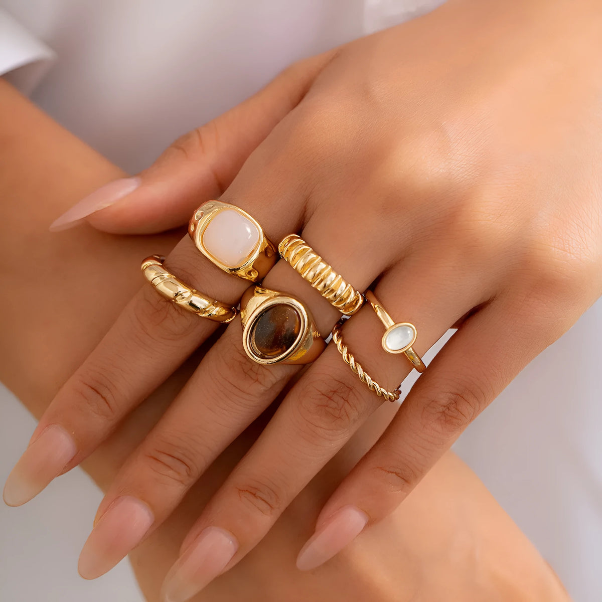 Six light gold electroplated alloy rings in a geometric set with round and ring shapes, style 94509