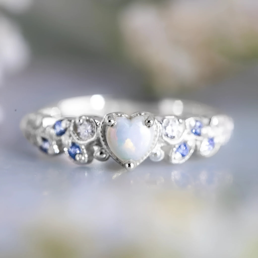 White electroplated alloy heart ring with detailed peach heart, opal stone, and floral ocean design.