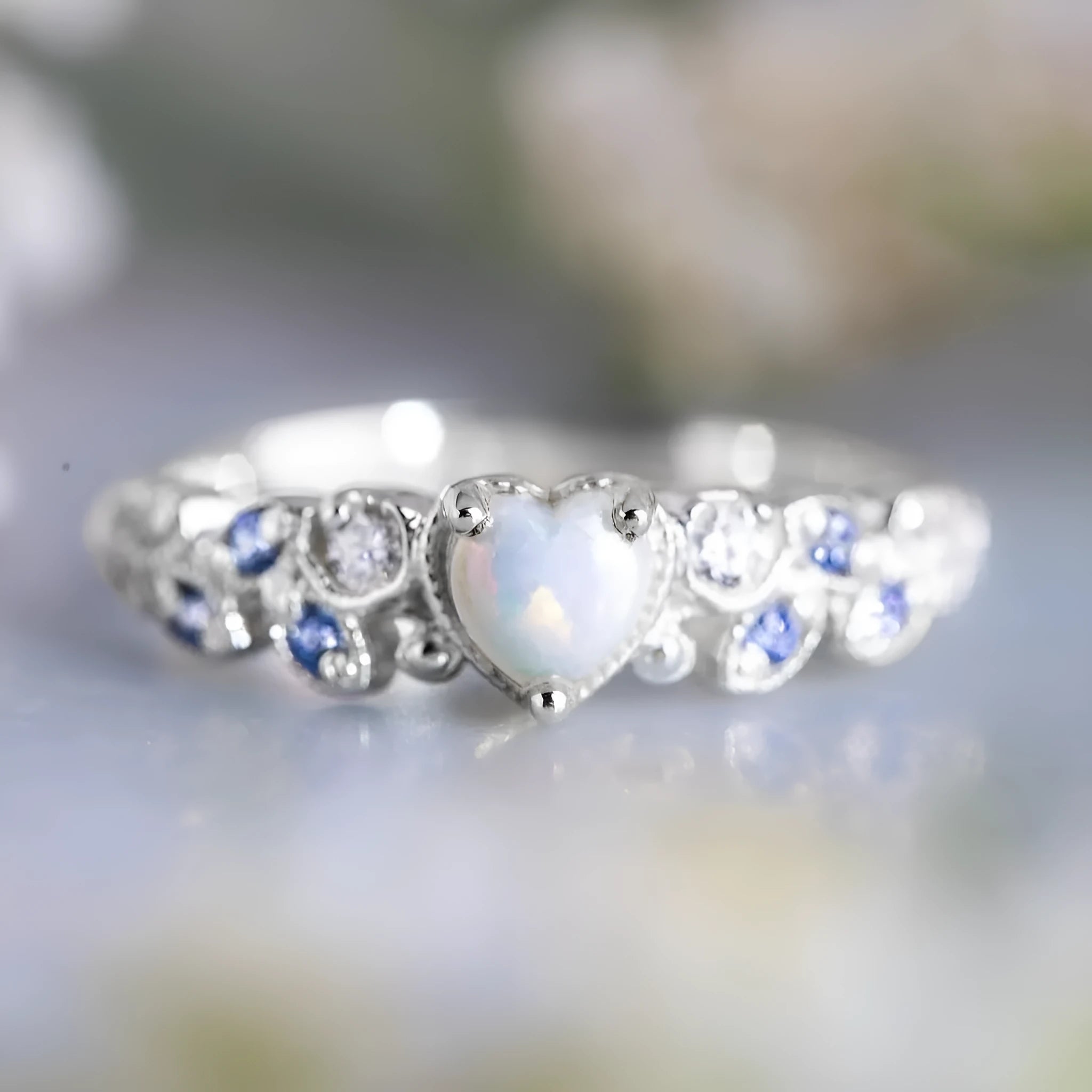 White electroplated alloy heart ring with detailed peach heart, opal stone, and floral ocean design.