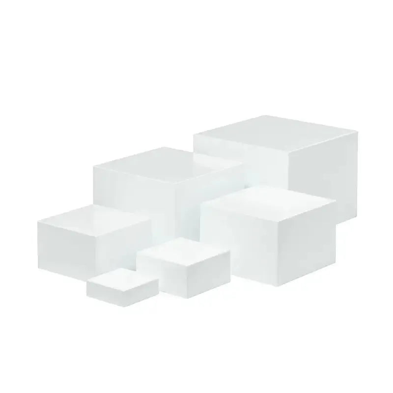 Set of six white plastic dessert display stands arranged on a tabletop.
