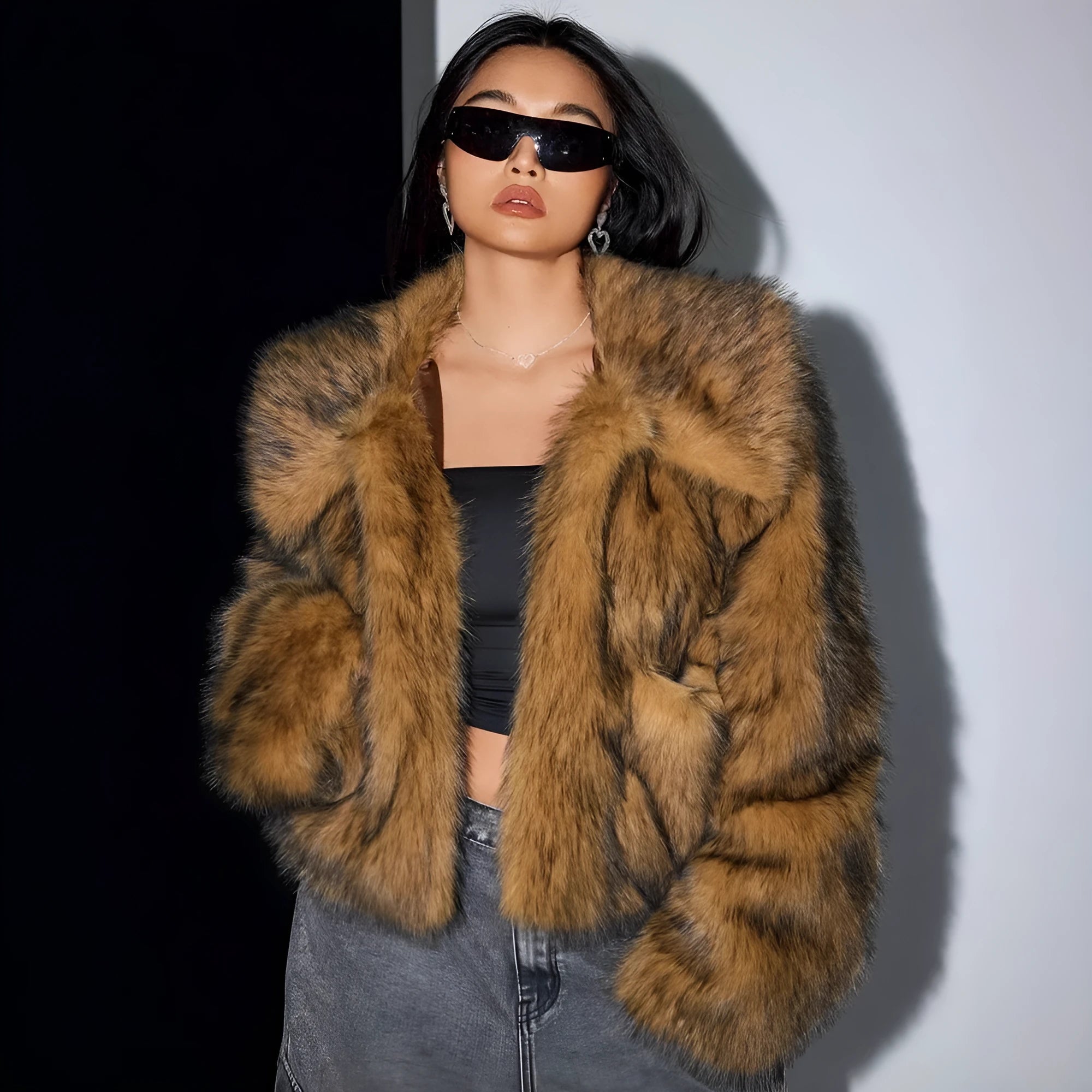 Women's short black and white artificial fur coat with a large fur collar, shown in a cute style pose.