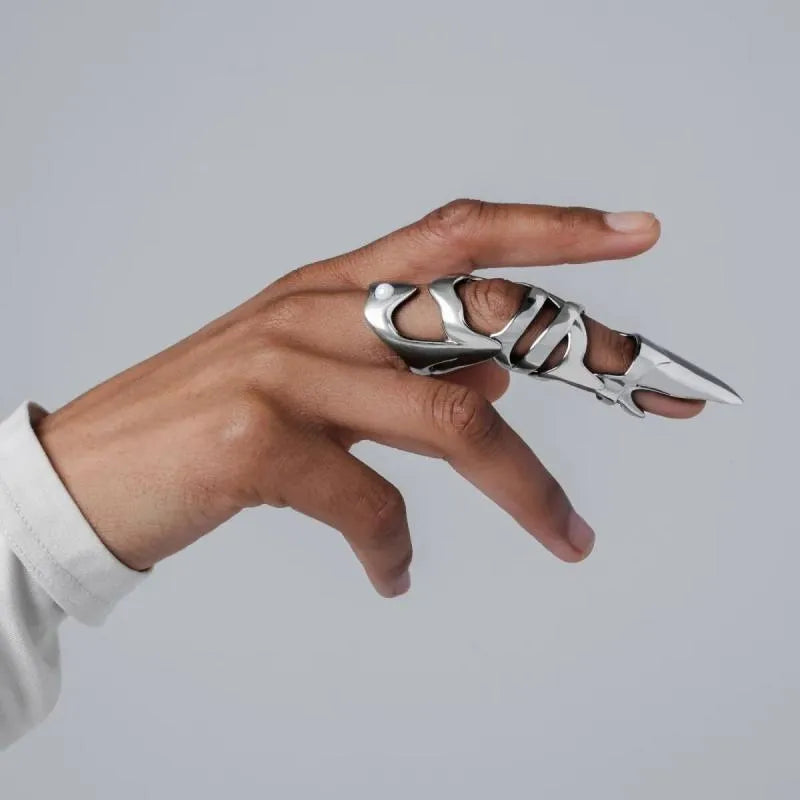 Silver punk armour finger stall with large geometric cutout on a model's finger.