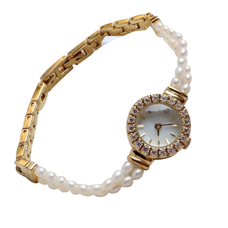 Light gold women's bracelet watch with freshwater pearls and a round 18mm dial.