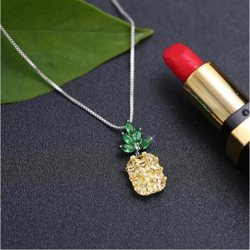 Silver geometric pineapple pendant necklace with a diamond accent on a model