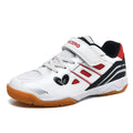 Low-top white and blue badminton shoes with a ribbed sole on a hard court surface.