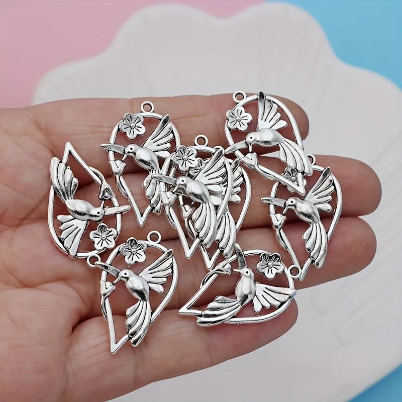 Close-up of a silver-toned magpie-shaped alloy pendant for DIY jewellery making, showing detailed feathers.