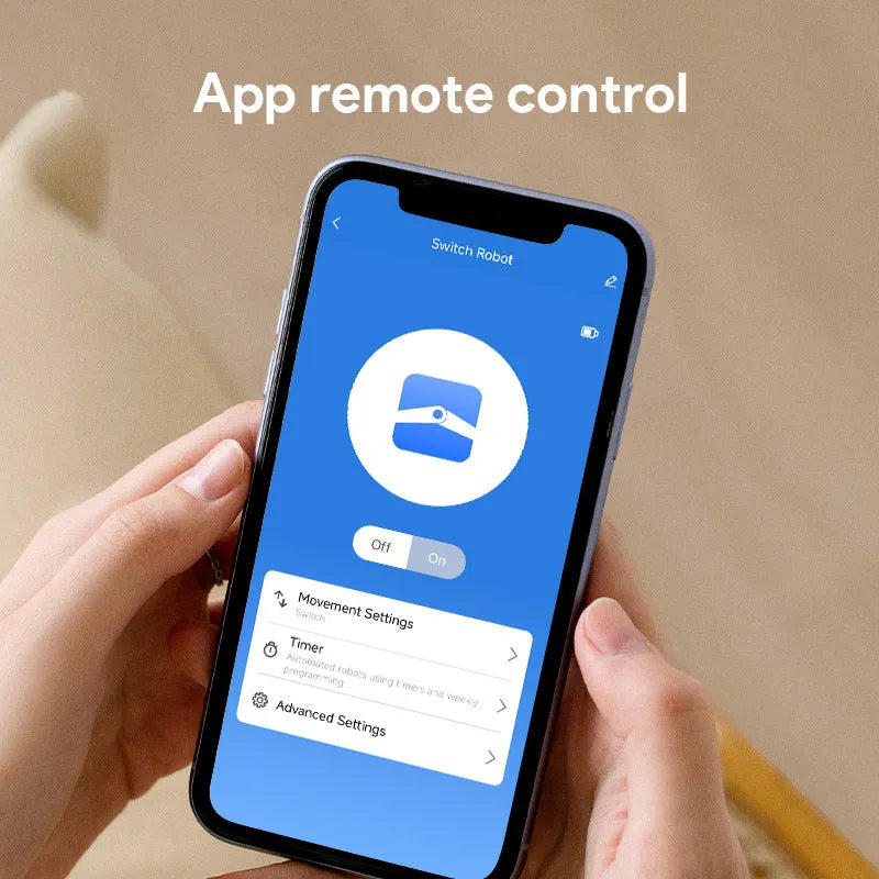 Small white Bluetooth finger remote with rocker arm switch, shown on a person's thumb.