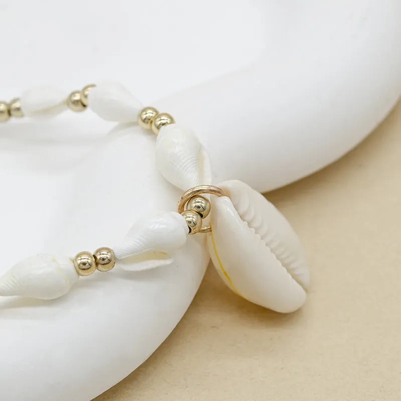 White electroplated shell necklace with conch bead mother-of-pearl pendant on a regular chain.