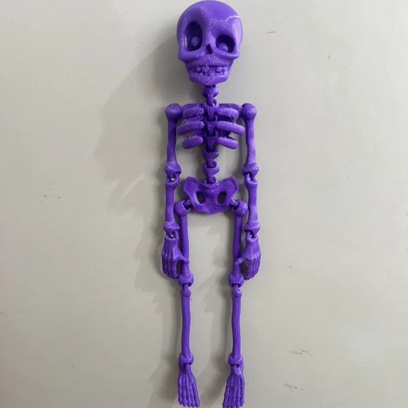 3D printed white skull fridge magnet ornament measuring 18cm tall on a refrigerator door.