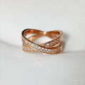 Close-up of a geometric cross ring on a hand, showing micro-inlaid zircon detail on a silver electroplated band.