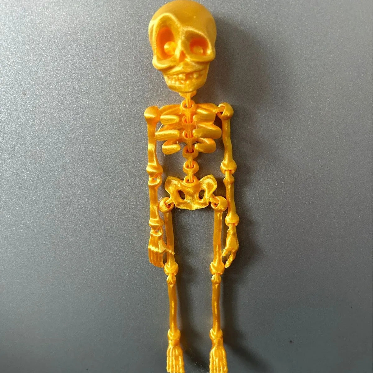 3D printed white skull fridge magnet ornament measuring 18cm tall on a refrigerator door.