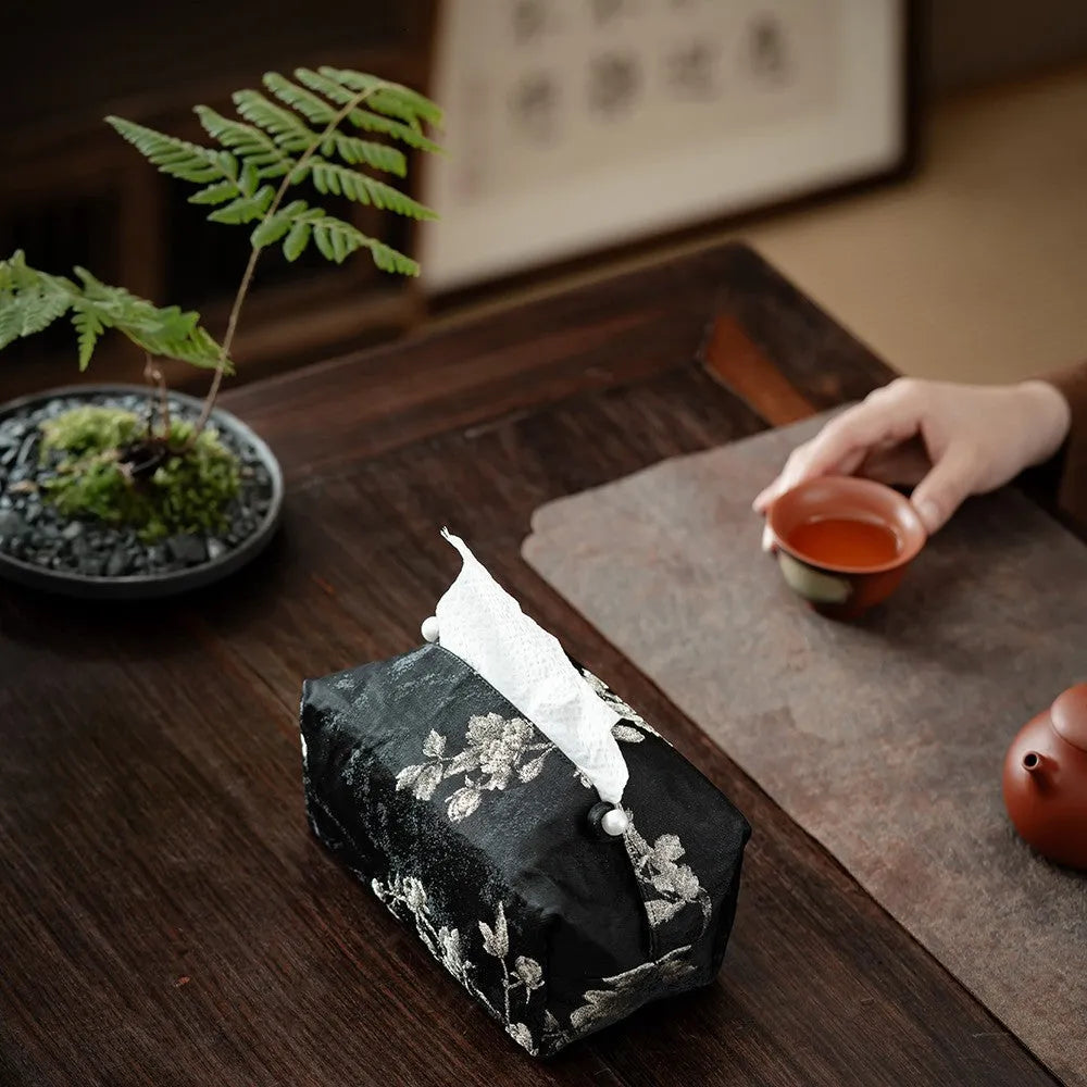 New Chinese style white brocade tissue box cover with embroidered plum blossoms on a table.