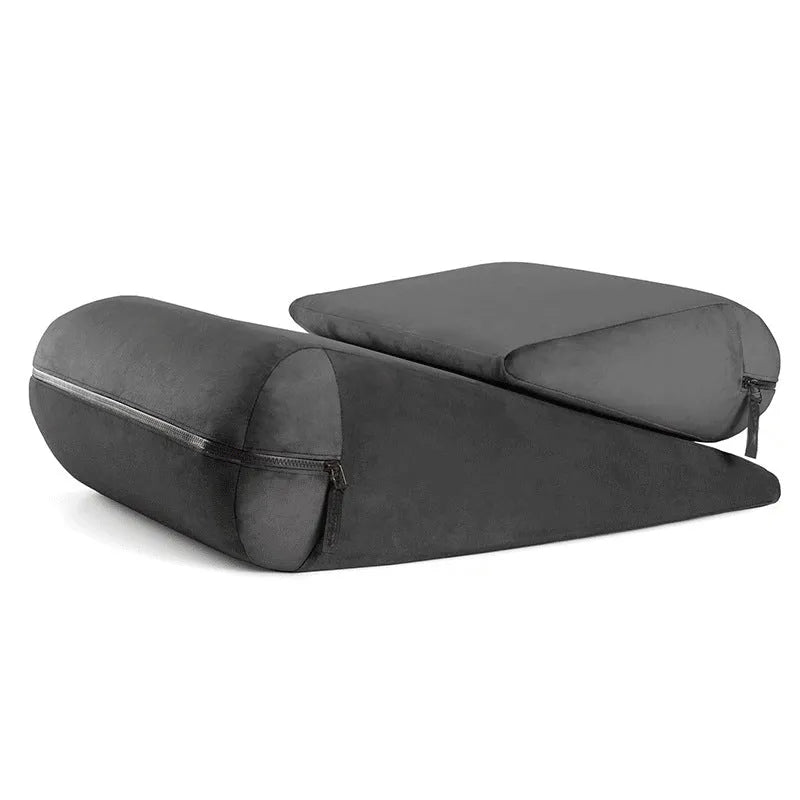 A grey embroidered triangle cushion pad on a sofa corner, showing its geometric wedge shape and textured surface.