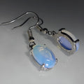 A pair of retro drop-shaped alloy earrings with electroplated moonstone opal colour and ellipse design elements.