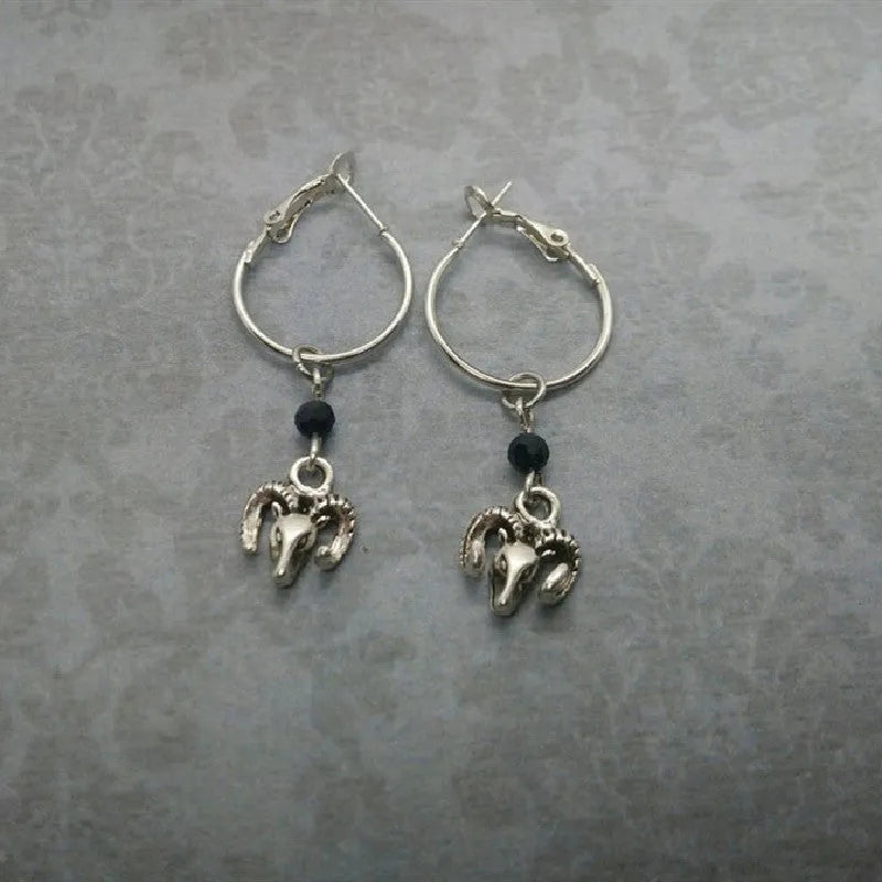 A pair of silver-coloured round ring earrings featuring a detailed Tibetan antelope design.