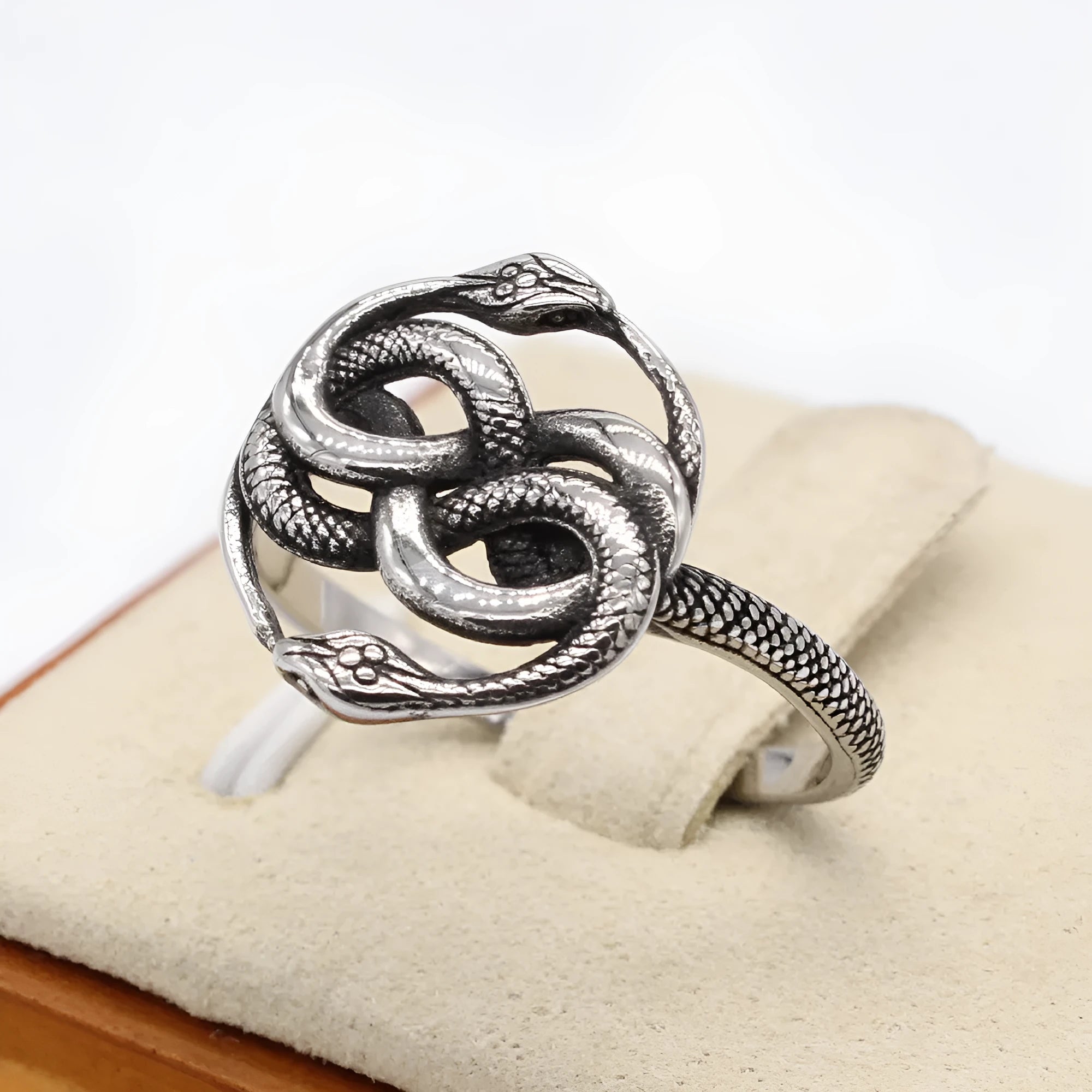 Close-up of a retro double snake coil ring in steel colour titanium steel on a model's hand.