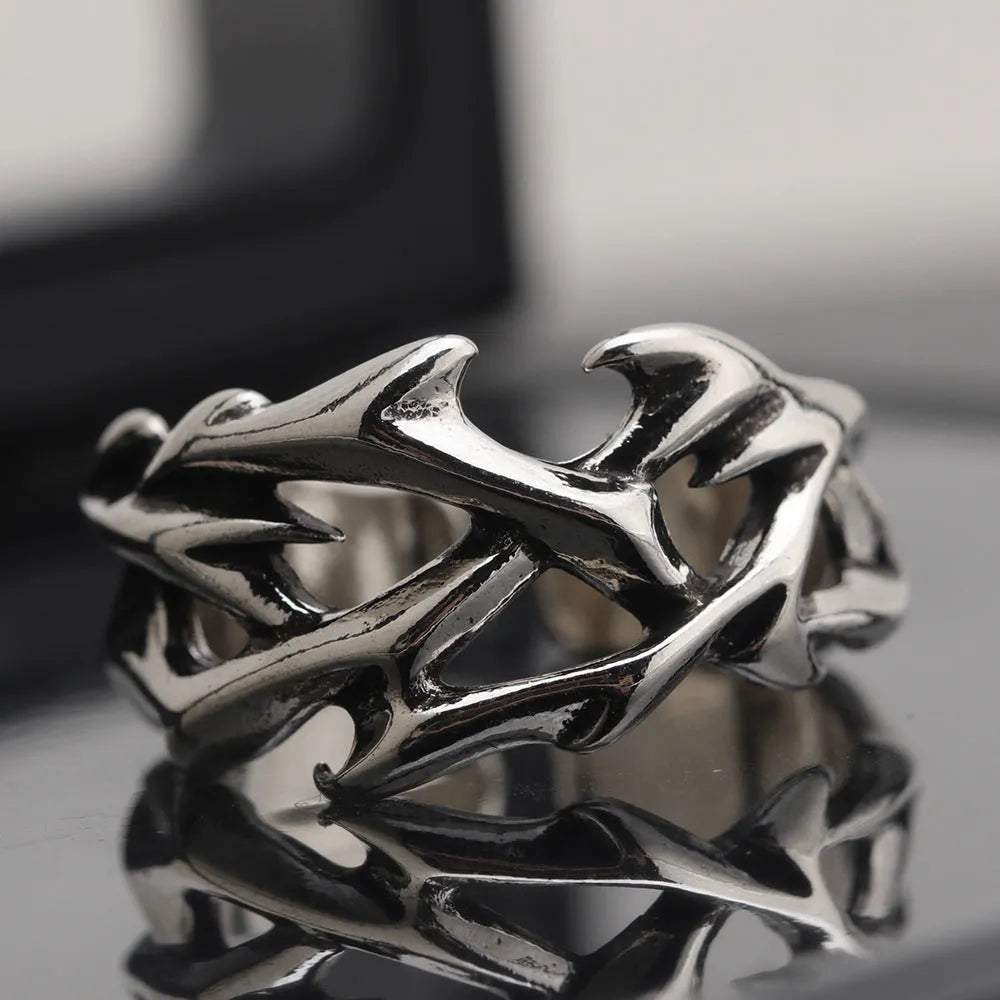 Copper men's ring with thorn and flower design on a geometric band, showing adjustable opening.
