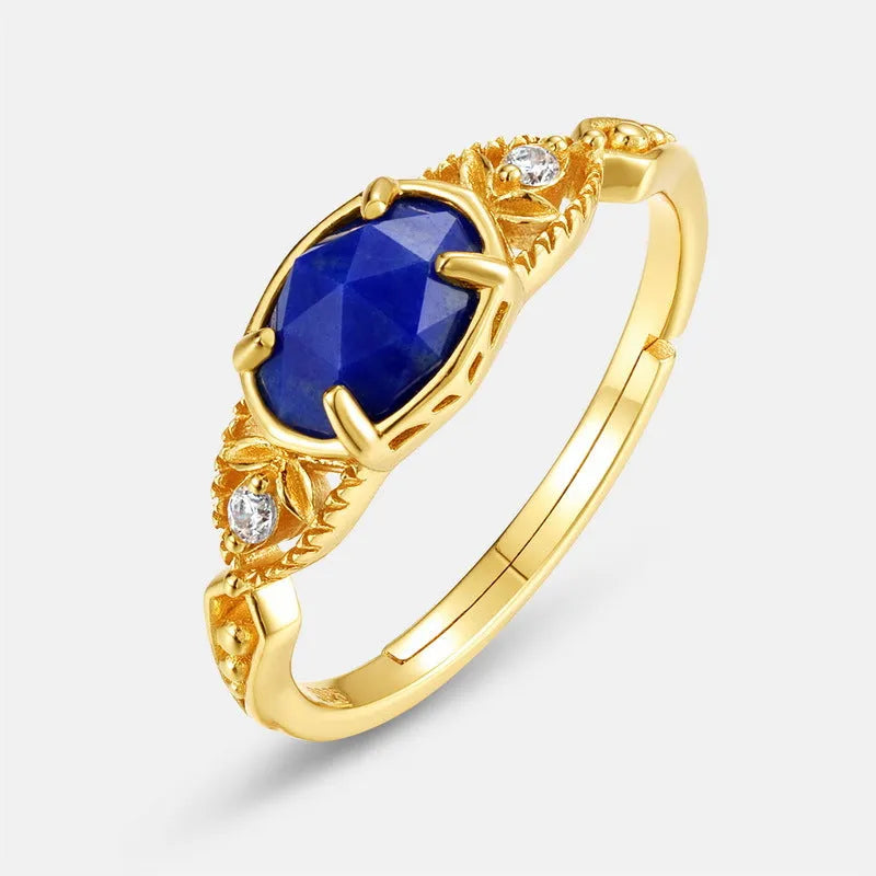 A geometric silver-tone alloy ring in a lapis lazuli colour, showing its elliptical profile and rounded elements.