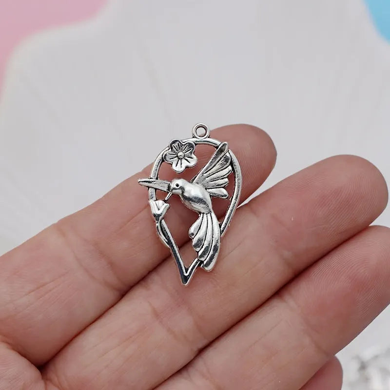 Close-up of a silver-toned magpie-shaped alloy pendant for DIY jewellery making, showing detailed feathers.