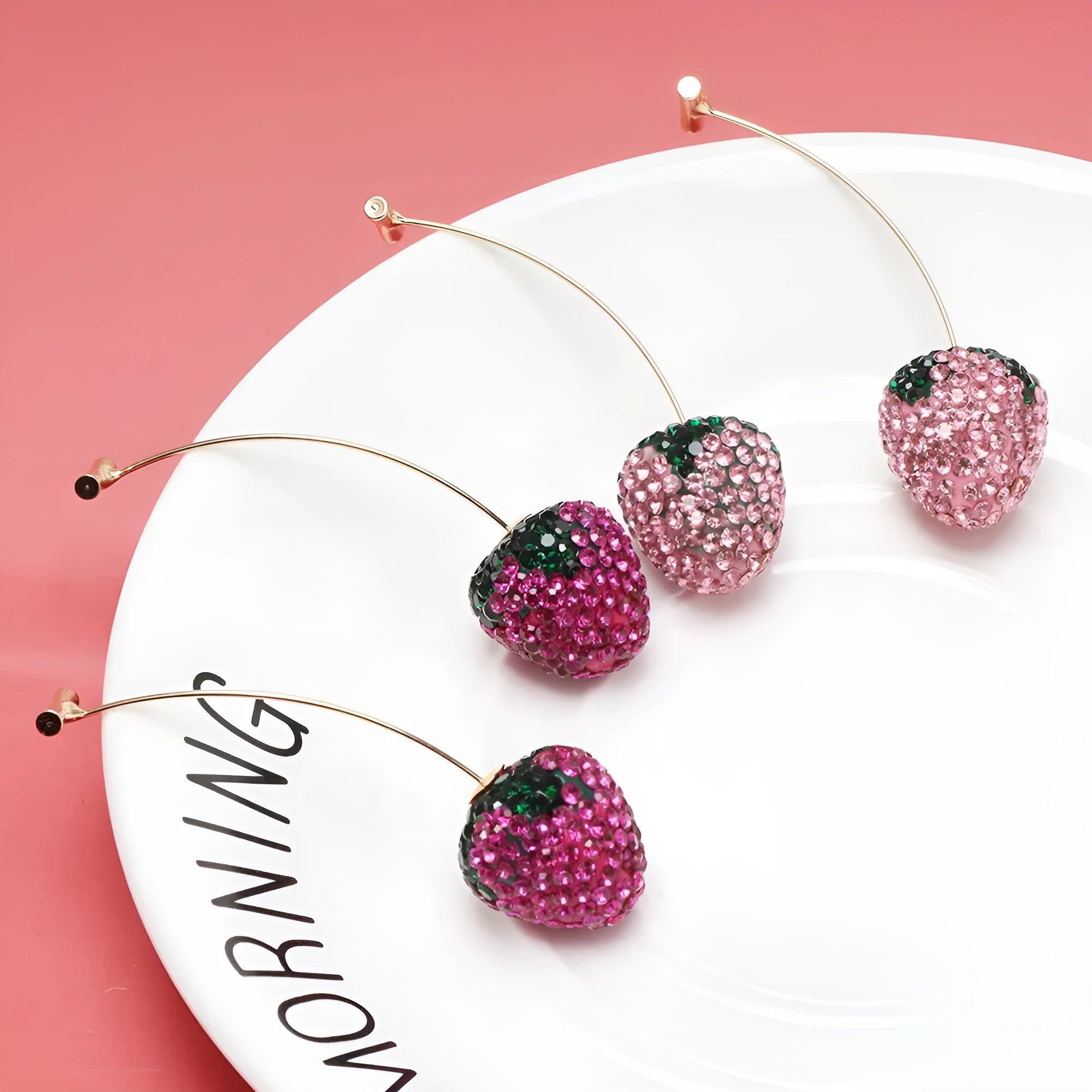Geometric strawberry-shaped zinc alloy earrings with spot-drill texture, shown in red, on a white background.