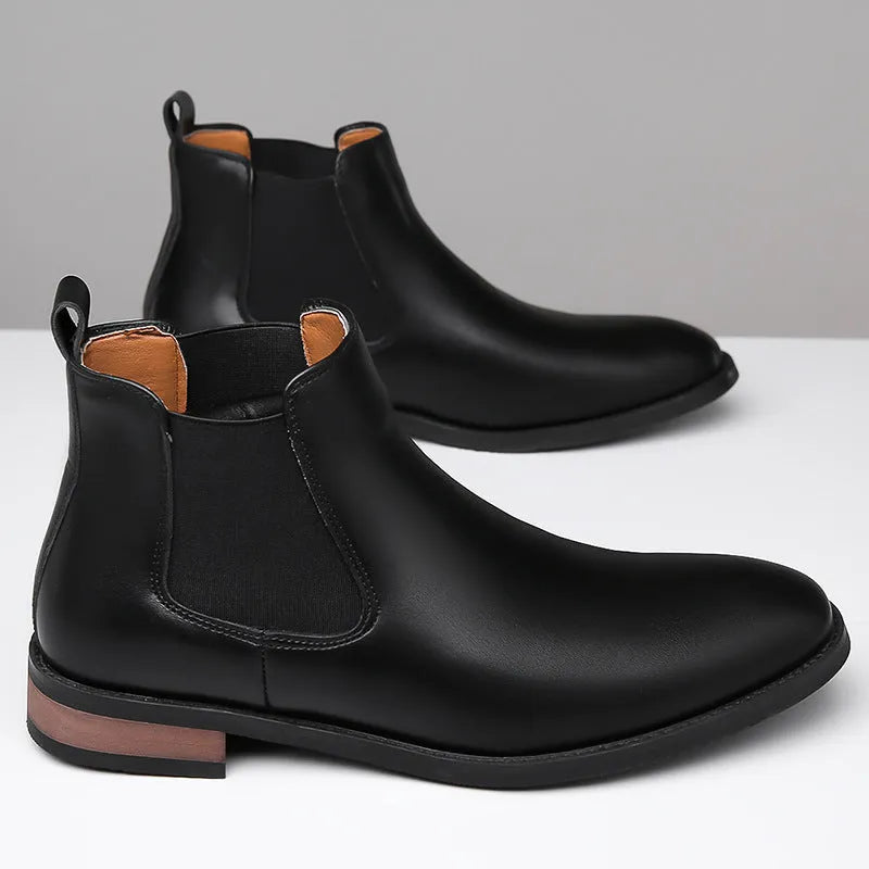 Men's black Chelsea boots with pointed toe design, sewing thread details and rubber sole