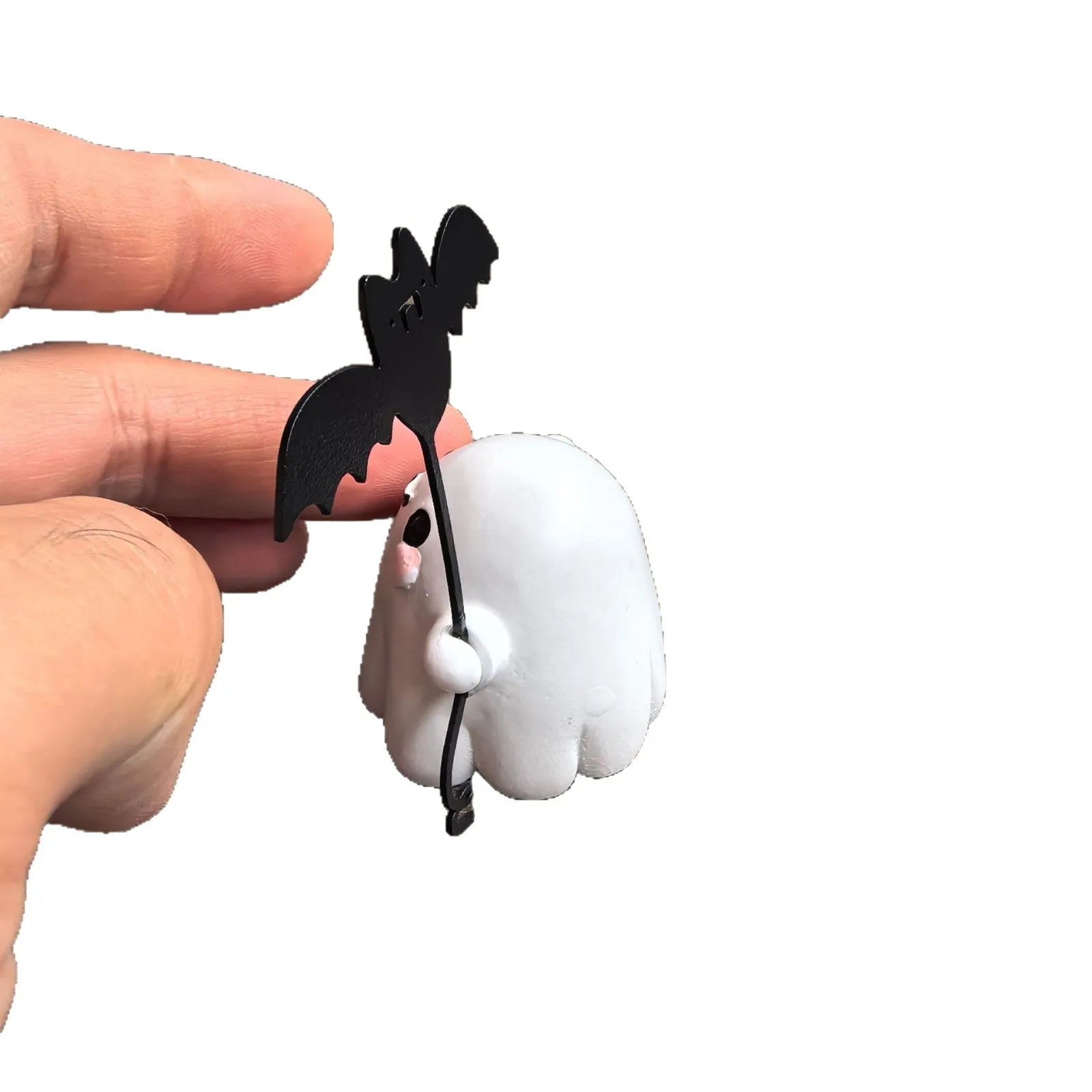 Mini resin Halloween statue of a white ghost dog walking and holding a small black bat.