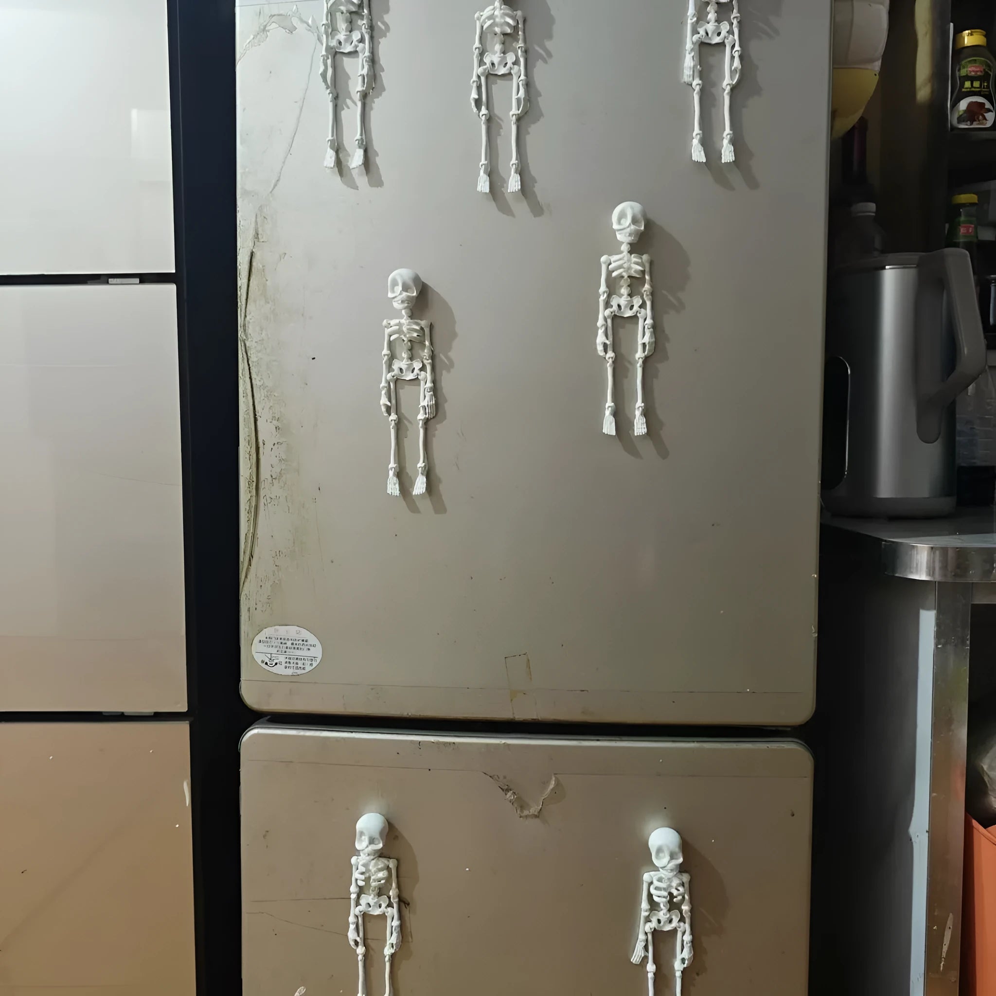 3D printed white skull fridge magnet ornament measuring 18cm tall on a refrigerator door.